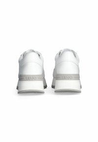 Zapatillas blancas con parte superior de cuero suave, silueta redondeada, acentos grises en la suela y una suela texturizada que presenta la marca.