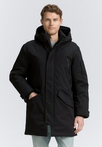Schwarze Parkajacke mit Kapuze, aus wasserdichtem Material. Verfügt �über Reißverschluss- und Knopftaschen sowie einen geraden Schnitt. Weiche Textur.