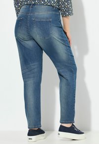 Světle modré džíny s rovnými nohavicemi, které mají dvě zadní kapsy a jemné zesvětlení. V kombinaci s námořnickými plátěnými botami.