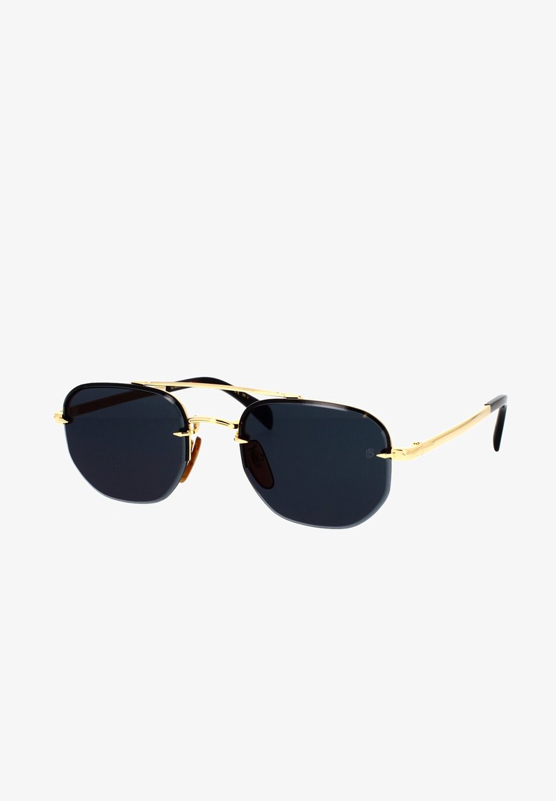 Päikeseprillid kuldsest metallraamist, mustade läätsede ja pruuni aktsendiga. Läätsed on kaheksanurkse kujuga ja neil on topelt sild.