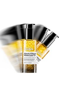 L'Oréal Professionnel Absolut Repair Molecular Oil i en gjennomsiktig flaske med gullbobler, svart pumpe og hvit etikett, 90 ml.
