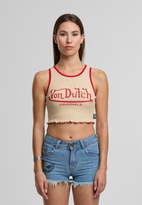 Hnedý top bez rukávov s červeným lemom a textom "Von Dutch ORIGINALS" v kombinácii s bledomodrými džínovými šortkami so strapcami a vyšívaným dizajnom.