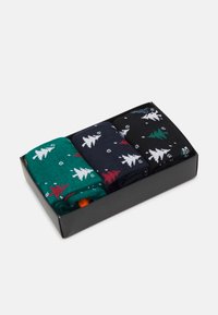 Tres pares de calcetines en una caja negra. Colores: verde con árboles blancos y rojos, azul marino con árboles blancos, negro con árboles verdes. Textura suave.