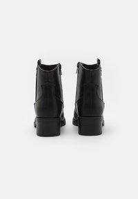 Czarne skórzane botki za kostkę o gładkim wykończeniu, z podwyższonym obcasem i zamkami błyskawicznymi po bokach. Posiadają detale szwów oraz okrągły czubek.