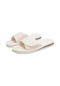 White slide sandals with a ridged strap and textured footbed. Features a soft material with a contrasting black stripe on the sole.