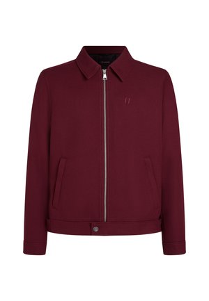 Burgundy jacket made from textured fabric, featuring a zip closure, two side pockets, and a collared neckline. Minimal branding detail.