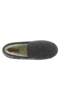 Zapatilla gris suave con un forro suave de color crema. Presenta un diseño de tipo slip-on y una etiqueta con el nombre de la marca "Ioamba". Textura lisa.