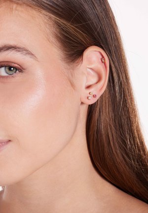 Ohrringe in Goldton mit rechteckigem Stecker und drei bunten Edelsteinen in Rosa, Gelb und Transparent. Glatte Textur, minimalistisches Design.