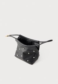 Zwarte leren schoudertas met kleine parelachtige studs en een magnetische sluiting, voorzien van een dunne riem en een gesp in goudkleur.