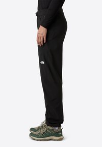 Crne vanjske hlače s petljama za pojas, izrađene od lagane tkanine, s bočnom džepom i logotipom The North Face na lijevom bedru.