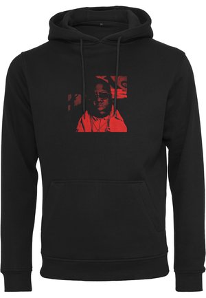 Svart hoodie med en framficka, med en röd grafisk tryck. Materialet verkar mjukt och texturerat, med justerbar dragsko på huvan.