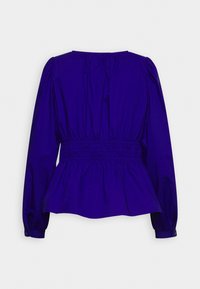 Top peplo viola con maniche lunghe a sbuffo e vita arricciata. Realizzato in tessuto morbido, presenta un collo rotondo e una trama semplice.