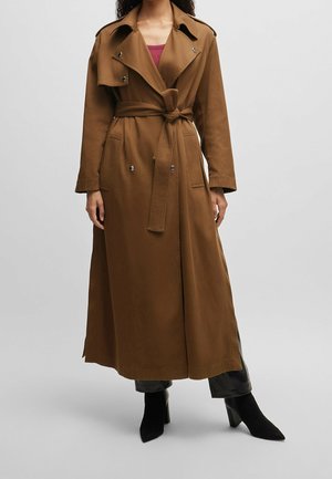 Brun trenchcoat med bælte i taljen, klapkrave, lange ærmer og to forlommer. Glat stof med en skræddersyet pasform.