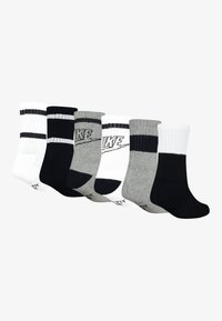 Šest parov posadnih nogavic v beli, črni in sivi barvi. Imajo rebrasto zasnovo, kontrastne črte in Nike logotip na nekaterih parih. Material iz mešanice bombaža.