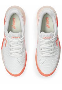 Zapatillas deportivas blancas con parte superior de malla transpirable, acentos naranjas, superficie texturizada y diseño clásico de cordones. Suela de goma que no deja marcas.