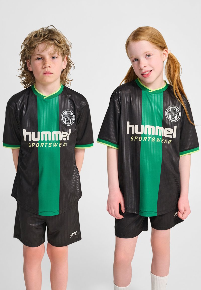 Svarta sporttröjor med en grön vertikal rand, korta ärmar och "hummel"-logotyp. Kombinera med svarta shorts och vita strumpor. Slät textur.