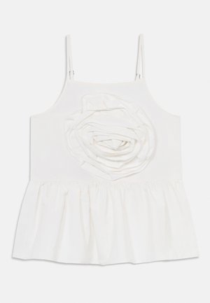 Haut blanc sans manches avec fines bretelles, présentant un grand détail de rose en tissu sur la poitrine et un ourlet peplum froncé.
