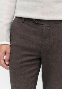 Brune vævede bukser med slim fit, featuring en flad front, knaplukning og to sidelommer. Stoffet har et struktureret udseende.