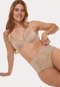 Beige bh met kantafwerking en zachte cups, passend hoge taille lace slip, gladde stof en bloemige kantaccenten op de rug.