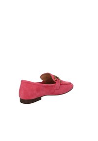 Scarpa slip-on in suede rosa con tacco basso, caratterizzata da un'elegante fibbia dorata e una punta arrotondata. Texture morbida e linee pulite.