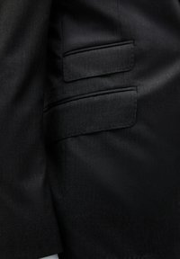 Tela de chaqueta de traje negra con una textura suave. Presenta un bolsillo de ojal en el lado superior, diseñado con líneas y costuras limpias.