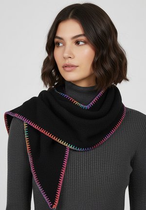 Woman with short dark hair wearing a dark gray ribbed turtleneck and a black scarf with multicolored stitched edges draped asymmetrically.