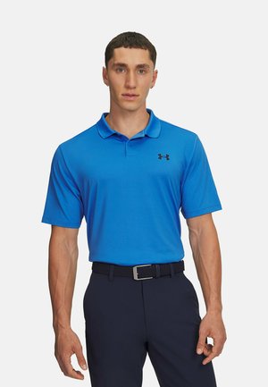 Camisa polo azul de manga corta, con cuello y logotipo negro bordado. Lleva pantalones navy y un cinturón negro texturizado.