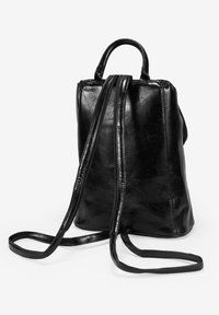 Mochila de cuero negro con dos asas superiores y correas largas ajustables. Presenta un acabado texturizado y suave con un cierre con cremallera.