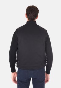 Gilet senza maniche nero con un motivo testurizzato, colletto alto e cinturini laterali regolabili, realizzato in un materiale leggero e traspirante.