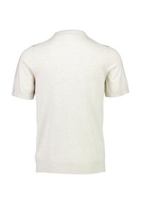 Ljusbeige kortärmad pikétröja i mjukt stickat tyg. Har en ribbad krage och nederkant med rena linjer och minimal detaljer.