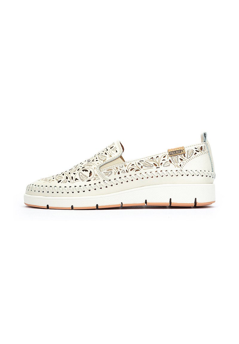 Zapatillas blancas sin cordones con intrincados patrones troquelados, un upper texturizado y una suela acolchada. Presenta costuras en contraste y una pequeña etiqueta de marca.