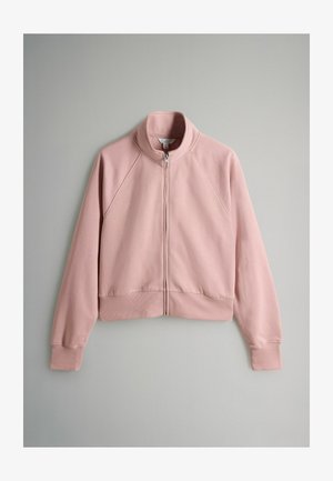 Rožinė užtrauktuku užsegama striukė, pagaminta iš minkštos medžiagos, su aukštu apykakle, raglano tipo rankovėmis bei įkamštais rankogaliais ir apačia, turinti lygią tekstūrą.