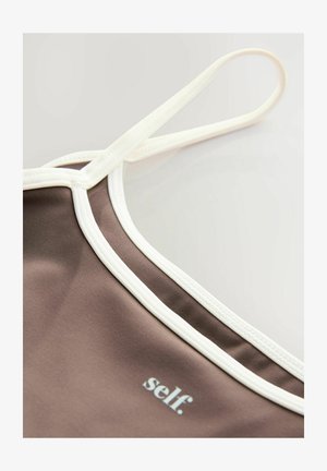 Débardeur en tissu marron avec des finitions blanches, doté de fines bretelles réglables et d'un petit logo "self.". Texture lisse, design minimaliste.