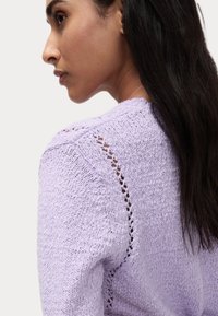 Maglione lavorato a maglia di colore viola chiaro con un motivo testurizzato e dettagli a punto aperto sulle spalle. Design aderente e tessuto morbido.