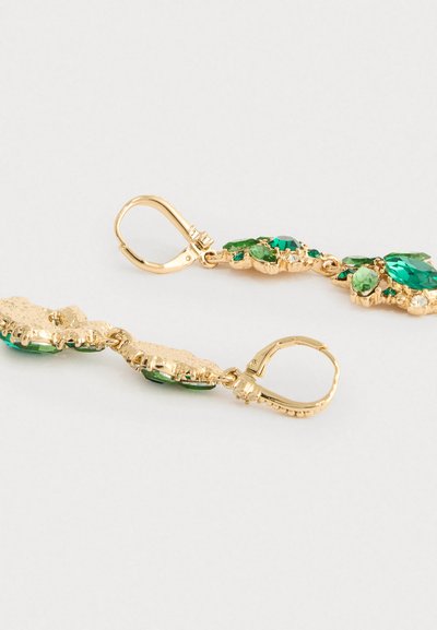 Złote kolczyki z fakturowanym wzorem falistym, ozdobione różnymi zielonymi kamieniami szlachetnymi w kształcie markizy i owalu.