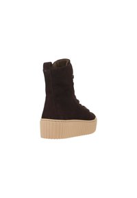 Brown suede ankle boot with a textured beige platform sole. Features lace-up front and a tab for easy wear. Smooth interior lining.