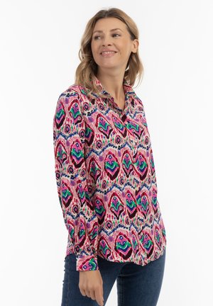 Blusa colorata con motivo in rosa, viola, verde e blu navy, dotata di colletto, maniche lunghe e chiusura a bottoni sul davanti con disegni intricati.