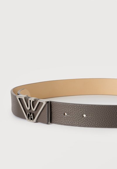 Ceinture en cuir gris texturé avec une boucle métallique argentée en forme d’un "W" stylisé et les lettres "GA" en dessous.