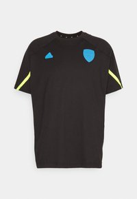 Černé sportovní tričko s krátkým rukávem, modrým logem a akcenty, a neonově žlutými pruhy na rukávech. Měkká tkanina, volný střih.