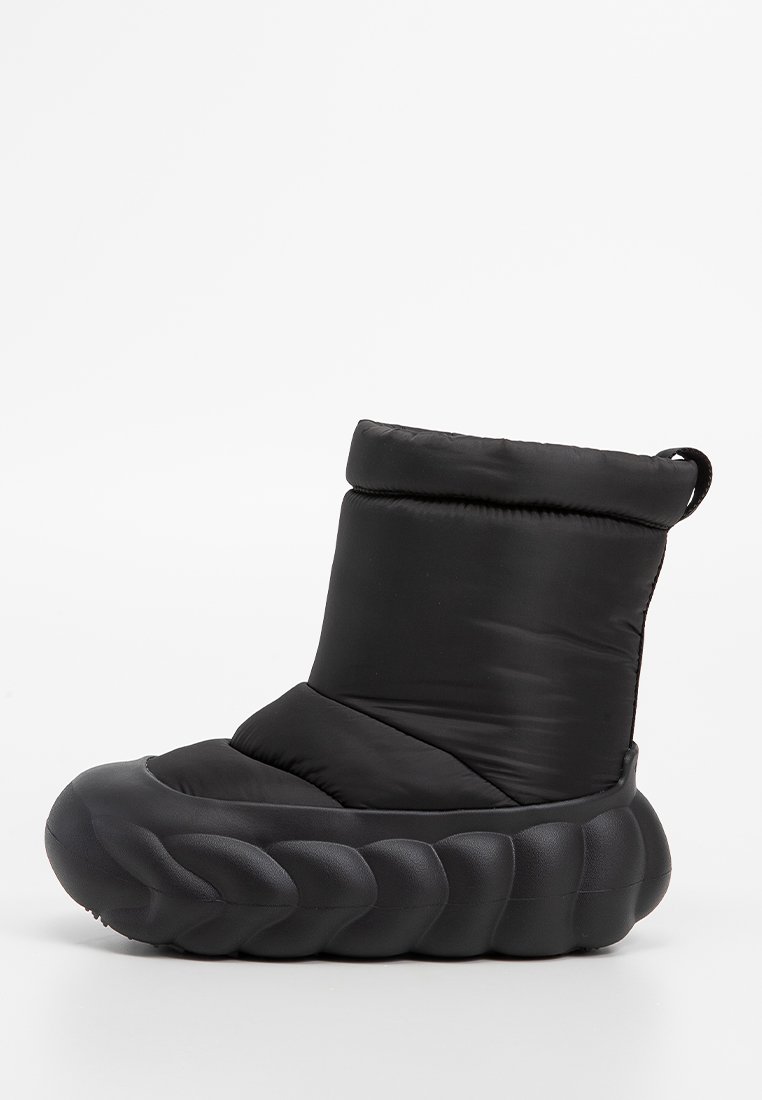 Schwarze gepolsterte Stiefel mit einer dicken, strukturierten Sohle, die ein geflochtenes Muster aufweist. Das Obermaterial ist weich und hat ein umgeschlagenes Bündchen-Design.