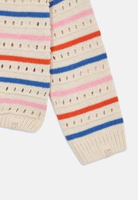 Pletený sveter s horizontálnymi pruhmi v ružovej, oranžovej, modrej a krémovej farbe, so ozdobnými otvormi a rebrovaným lemom označeným "ONLY."