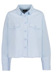 Světle modrá zkrácená bunda z bavlny s knoflíkovou přední částí, dvěma náprsními kapsami a třásňovým lemem. Má dlouhé rukávy a límec.