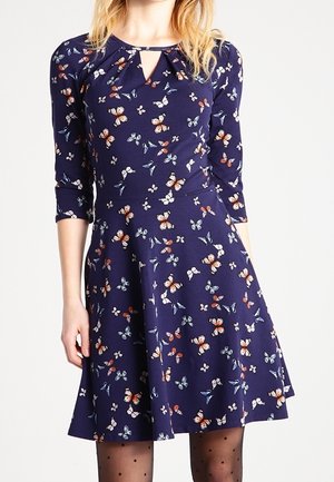 Robe bleu marine avec des manches trois-quarts, décolleté en trou de serrure et imprimé papillon dans diverses couleurs. Design de jupe évasée, texture de tissu douce.