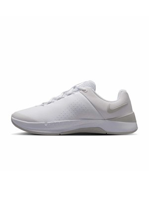 Hvid atletik-sneaker med mesh-stof, snøredesign, polstret sål og et sølvfarvet Nike-logo på siden.
