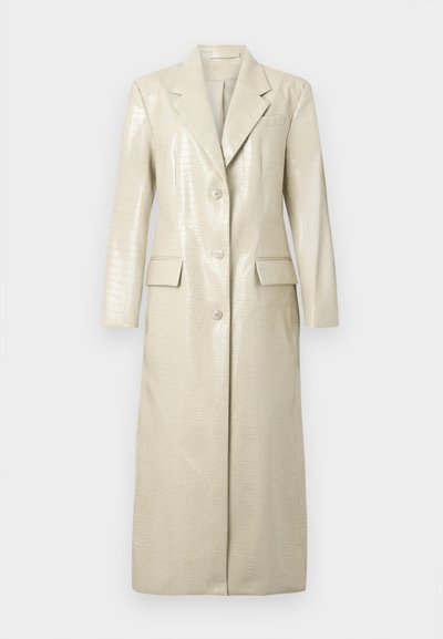 Krokodilmuster Kunstleder lange Jacke, hellbeige, mit Reverskragen, zwei Fronttaschen und Knopfverschluss. Glatte, glänzende Textur.