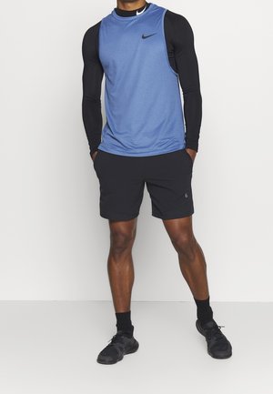 T-shirt de sport bleu sans manches avec manches longues noires et short noir. Logo Nike présent sur le t-shirt et le short. Le tissu semble léger.