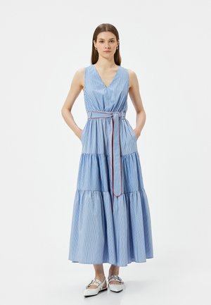 Abito maxi a righe blu e bianche con scollatura a V, design senza maniche, vita cinchata con cintura e gonna a strati. Include tasche.