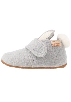Pantofole grigie in feltro con punta arrotondata, cinturino regolabile e un morbido pompon bianco sul retro. Presentano una morbida fodera e una suola in gomma.