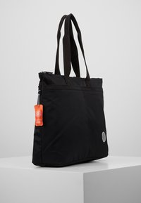 Sac fourre-tout en nylon noir avec poignées doubles en boucle, fermeture éclair et une étiquette de marque orange. Présente un logo circulaire sur le côté.