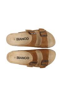 Sandalias de ante marrón con dos hebillas metálicas negras ajustables, plantilla contorneada y una plantilla beige con "BIANCO" impreso en ella.